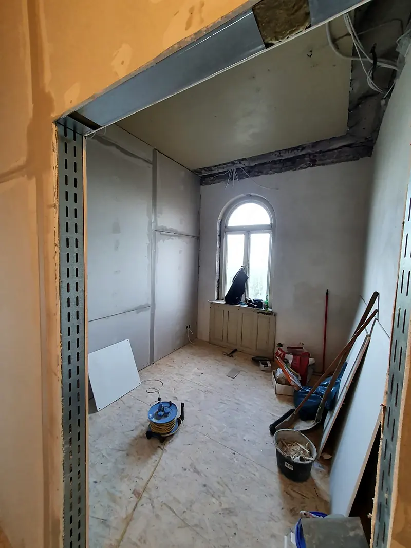 Altbau-Sanierung mit neuen Trockenbauwänden – vorher (Ständerwerk und fertiges Zimmer)